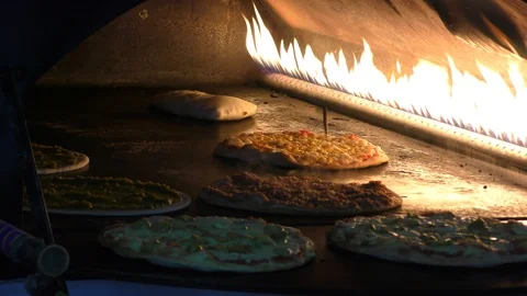 Making Mediterranean Pita Bread style pizza in traditional oven Video stock 100246520