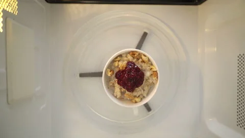 Making microwave mug breakfast meal. Nut and jelly oatmeal Stock Footage