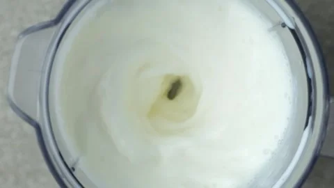 Making a milkshake in a blender bowl, top view, slow motion. Stock Footage 311697821