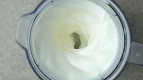 Making a milkshake in a blender bowl, top view, slow motion. Stock Footage 312605192