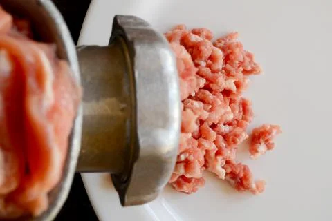 Making minced meat with a meat grinder and red raw mince on a white plate Stock Photos