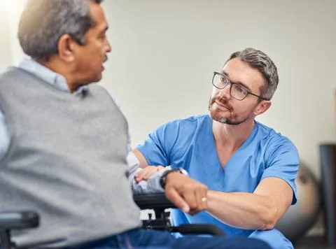Making mobility a bit more easier. a nurse helping a senior man in a wheelchair. Stock Photos