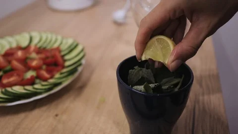 Making mojito cocktail, squeezing lime juice into a glass with mint and ice Stock Footage 111399950
