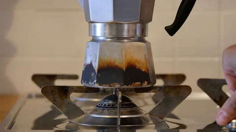 Making moka coffee at kitchen. Home breakfast routine. a woman turn on the gas  Video stock 128239335