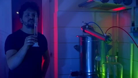 Making moonshine. A man makes homemade alcohol. Checking the strength of the Stock Footage 125639802