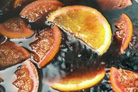 Making of mulled wine or punch with slices of orange, anise slice, cinnamon a Stock Photos
