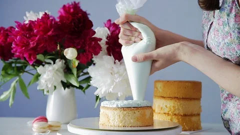 Making multilayered layer cake, adding cream filling from confectionery bag. Stock Footage 105448074