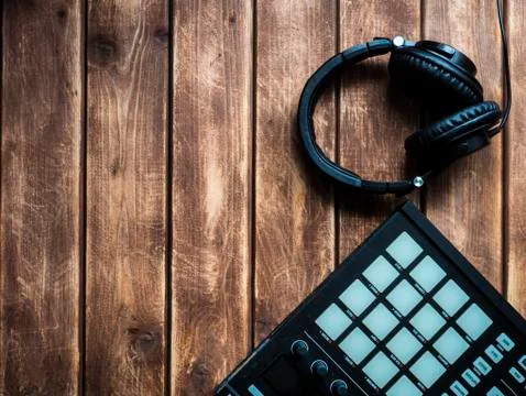 Making music with controller with pads and headphones on a wooden surface wit Stock Photos