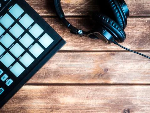 Making music with controller with pads and headphones on a wooden surface wit Stock Photos