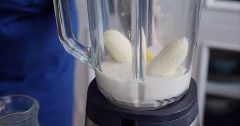 Making an oat milk smoothie with mango and banana Stock Footage 125130187