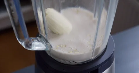 Making an oat milk smoothie with mango and banana Stock Footage 125130511
