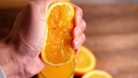 Making orange juice pressing half of orange. Close up of hands squeezing or.. Stock Footage 265840854