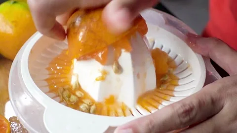 Making orange juice pressing half of orange. Close up of hands squeezing or.. Stock Footage 265841122