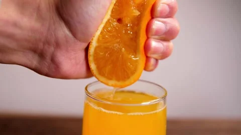Making orange juice pressing half of orange. Close up of hands squeezing orange Stock-Footage 336588871