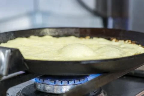 Making pancakes on frying pan. The process of cooking pancakes on a hot fryin Stock Photos