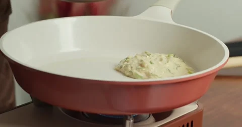 Making pancakes from grated zucchini. Close-up of zucchini fritters frying in Stock Footage 317405084