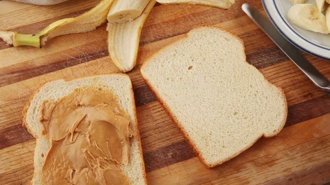 Making peanut butter, chocolate spread and banana sandwich Stock-Footage 93002064