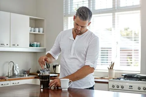 Making the perfect brew. a man drinking coffee in the morning at home. Stock Photos