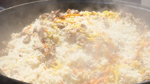 Making pilau outdoor on open fire in cauldron. Mixes prepared pilaf Vidéo 113526536
