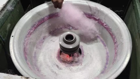 Making pink cotton candy in machine spinning bowl Stock Footage 346659789
