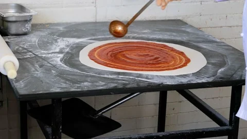 Making pizza base greased with tomato sauce Video stock 153608371