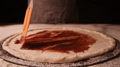 Making pizza at kitchen. Close up on chef putting tomato sauce on pizza Vídeos de archivo 149079485