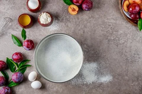 Making plum pie process, ingredients on kitchen table. Stock Photos
