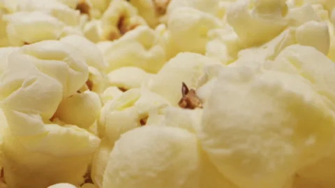 Making popcorn on black pan close-up macro. Corn kernels are popping and cooking Stock Footage 261592294