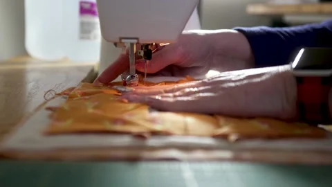 Making a potholder by stitching quilt scraps together in slow motion - Stock Footage 167627590