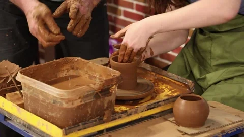 Making pottery by a craftswoman under the supervision of a teacher Stock Footage 340143813