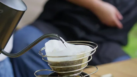 Making pour over coffee with a gooseneck kettle outdoors Stock Footage 344577452