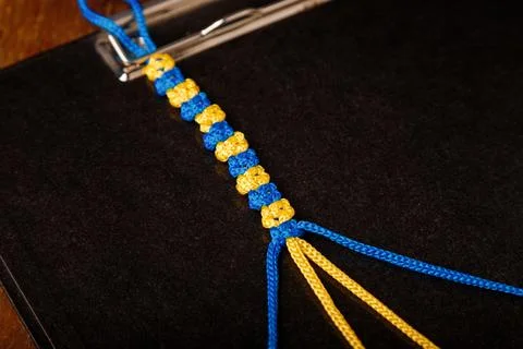 Making process of macrame wristband, paracord bracelet in national Ukrainian Stock Photos