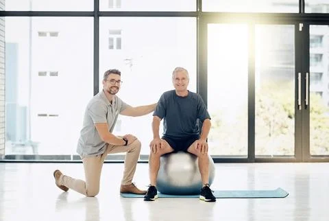 Making progress at a comfortable pace. a caring physiotherapist helping his Stock Photos