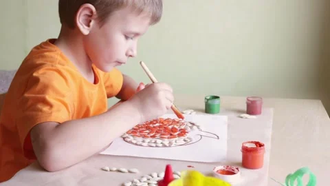 Making pumpkin from seeds on white paper, Halloween DIY concept Stock Footage 141243450