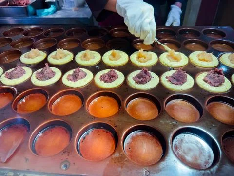 Making red bean paste cake with a metal plate machine and white cream in Tokyo Foto stock