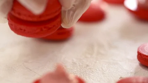 Making Red Macaroons. Close up shot of connecting two halves of macaroons with Video stock 129785473
