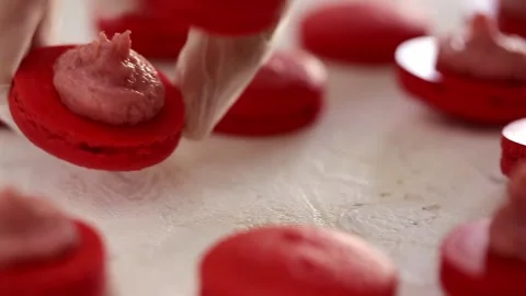 Making Red Macaroons. Close up shot of connecting two halves of macaroons with Stock Footage 130673307