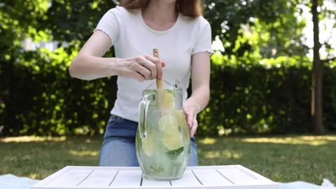 Making a refreshing mint lemonade in the garden on a sunny day Stock Footage 297370278