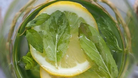Making refreshing mint lemonade with lemon and mint leaves Stock Footage 345385086