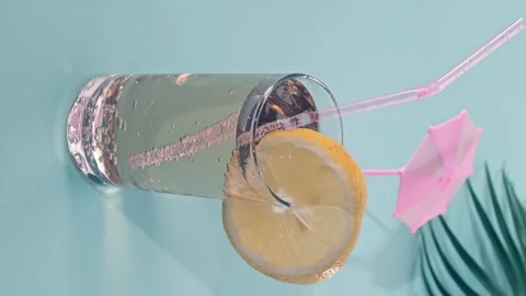 Making a refreshing soda lemonade with a slice of lemon and an umbrella Stock Footage 341410522