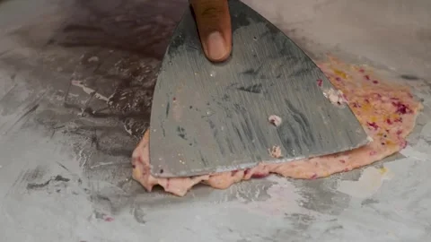 Making rolled ice cream with mixed dragon fruits and mango on a cold plate at a Stock Footage 284345554