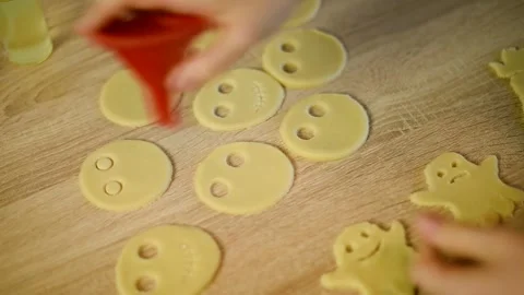 Making round eyes holes on raw cookie dough shapes close up Stock Footage 342704157