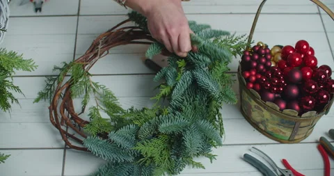 Making rustic christmas wreath. Hands holding green branches on rustic wooden Stock Footage 146041674