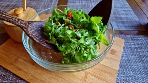 Making a salad of arugula, tomatoes and cucumbers with olive oil. Fresh Stock Footage 263205997