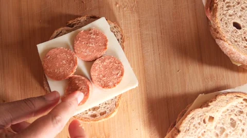 Making sandwich with bread cheese and pepperoni on wooden board motion. Видео 332578746