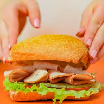 Making a sandwich with ham and lettuce on a soft roll Stock Photos