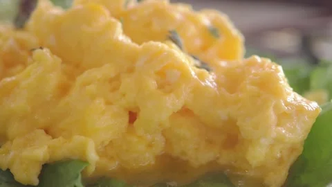 Making scrambled eggs on a bed of spinach Stock Footage 344724086