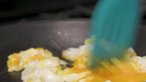 Making scrambled eggs close up in a kitchen skillet or frying pan Stock Footage 288020069