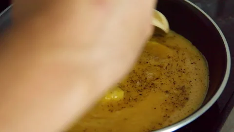 Making scrambled eggs in frying pan, stirring eggs with wooden spoon Stock Footage 164869308