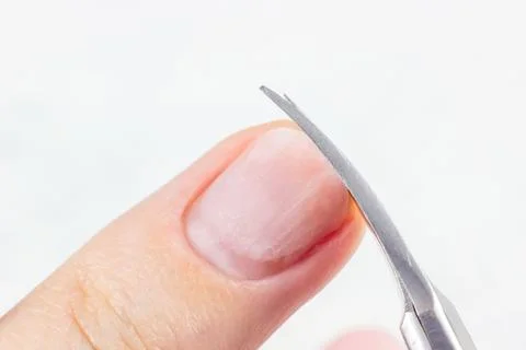 Making self manicure at home with the help of nail scissors close up Stock Photos